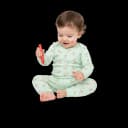 Cheerful toddler sitting and scribbling with a red crayon, showing early fine motor skills and creative expression.