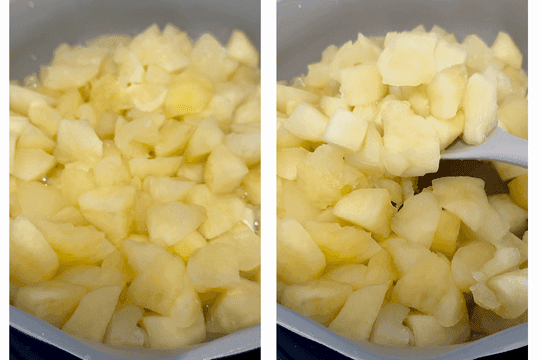 Simmering apples in a saucepan on low heat for 15 minutes, stirred occasionally until soft and broken down for applesauce.