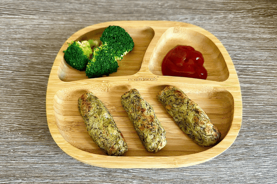 A baby-friendly meal featuring homemade potato broccoli tots served on a wooden plate with steamed broccoli and ketchup for dipping. A healthy and delicious finger food option for toddlers.