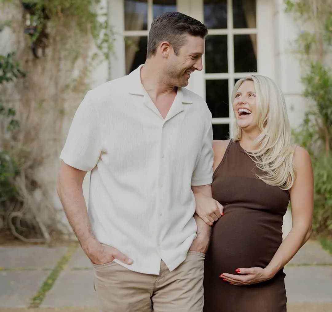 "Happy pregnant couple smiling and walking outdoors, expecting baby soon"