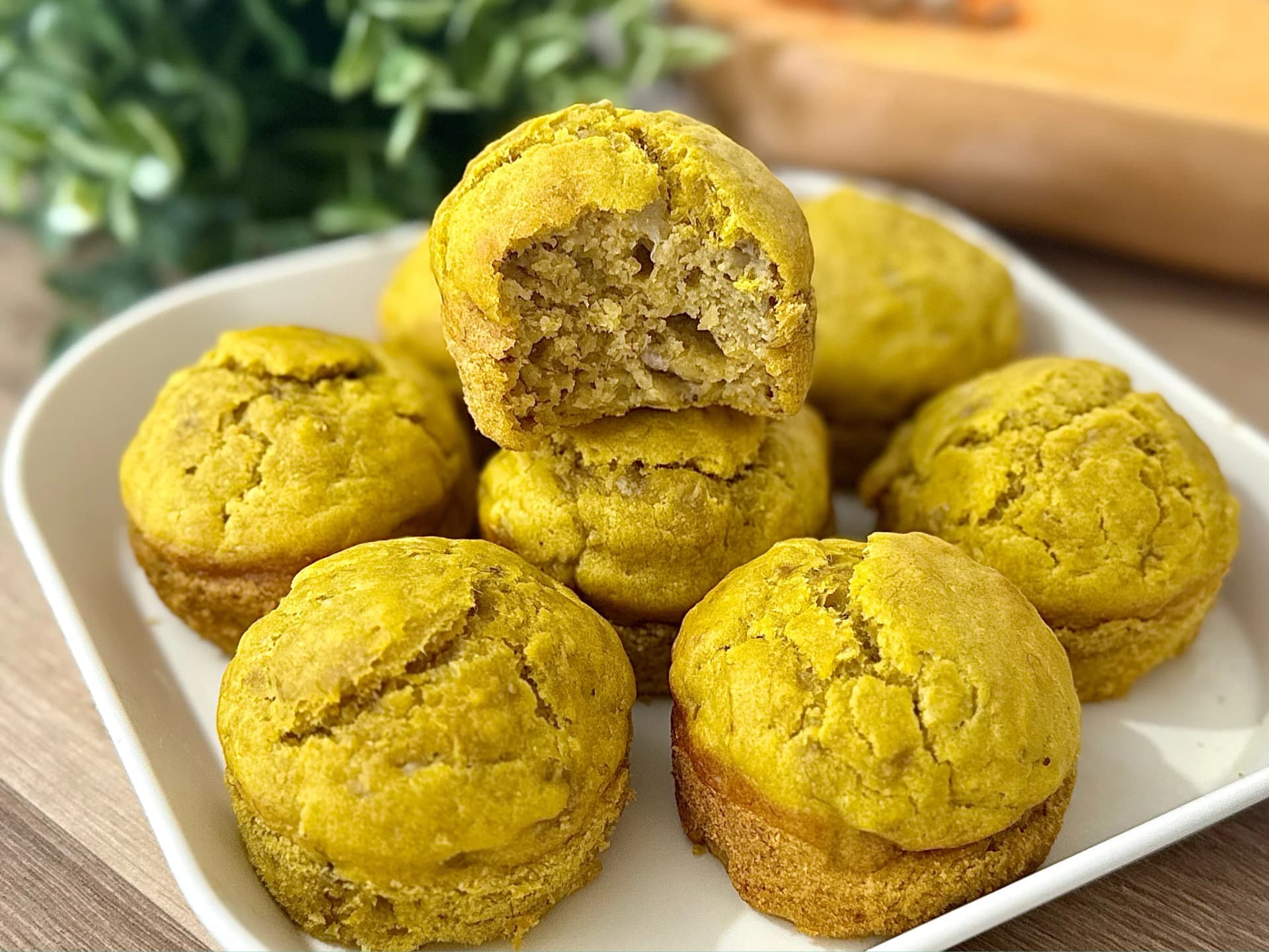 "Golden butternut squash muffins, one bitten to show soft texture. Ideal for baby-led weaning or healthy snacks."