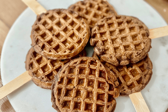 Freshly cooked waffle pops cooling on a plate, ready to be served warm with a soft texture safe for babies.