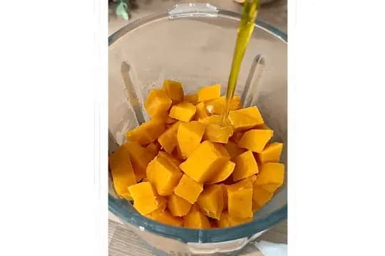 Chopped sweet potatoes in a blender, ready to be blended into a smooth puree.