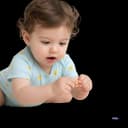 Cute baby or toddler on the floor using a pincer grasp (thumb and forefinger) to pick up a small piece of cereal, illustrating fine motor skill development.