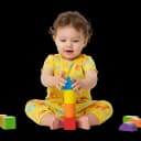 Happy baby or toddler sitting and stacking blocks, demonstrating fine motor skills, hand-eye coordination, and early problem-solving.