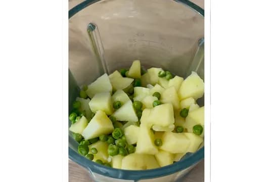 "Boiled peas and potatoes in a blender pitcher, preparing for blending into a healthy puree or baby food."