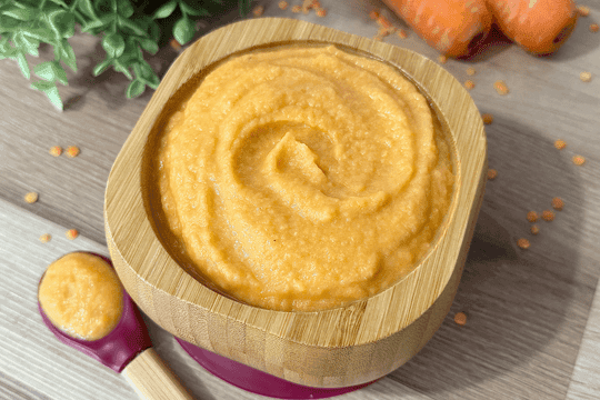 An image of of a bowl of carrot lentii puree for baby's consumption.