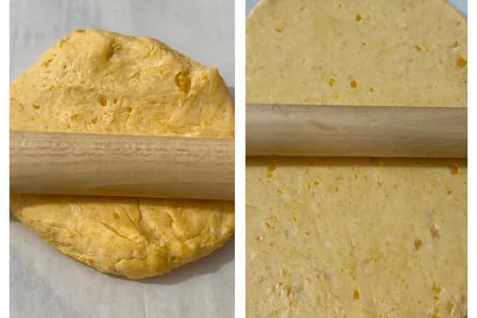 Rolling out banana bread dough thinly on parchment paper for crispy homemade crackers