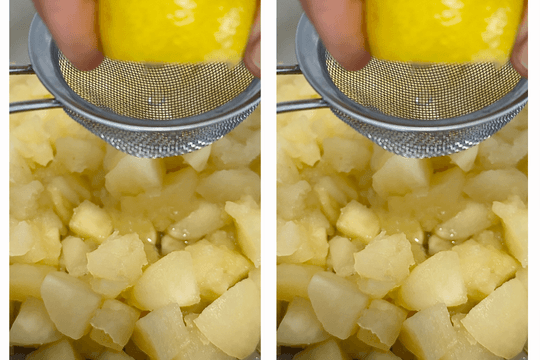 Stirring lemon juice into tender cooked apples to enhance flavor and preserve color in homemade applesauce.
