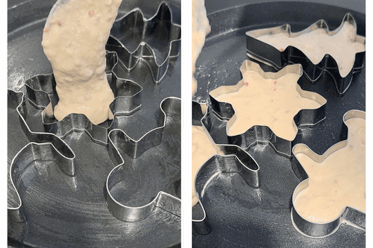 Cooking pancake batter in greased cookie cutters on a non-stick pan, forming festive shapes for Christmas breakfast.