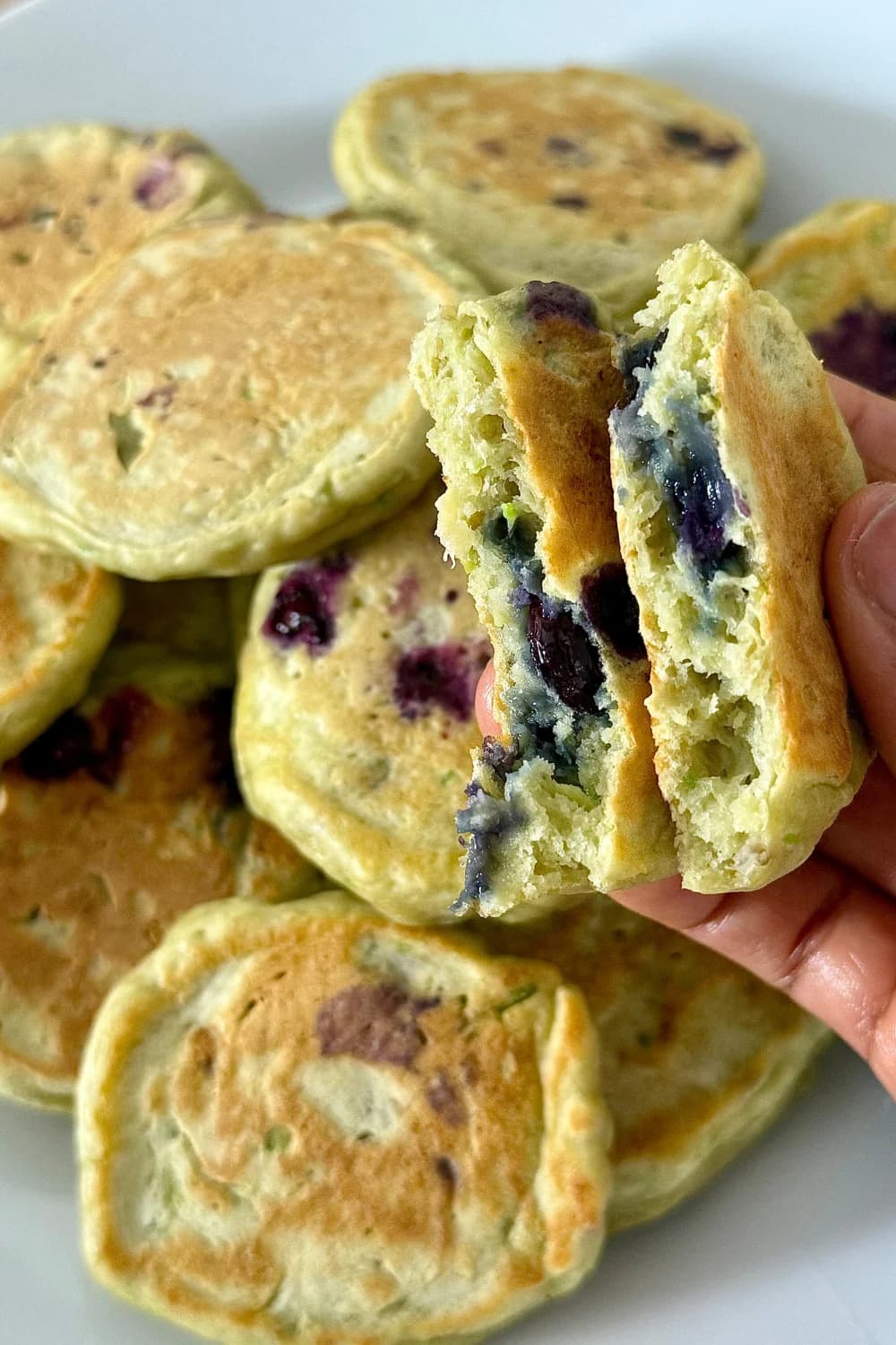 "Avocado blueberry pancakes served with fresh blueberries and yogurt on a toddler-friendly divided plate, ideal for healthy kids' breakfast or snack"