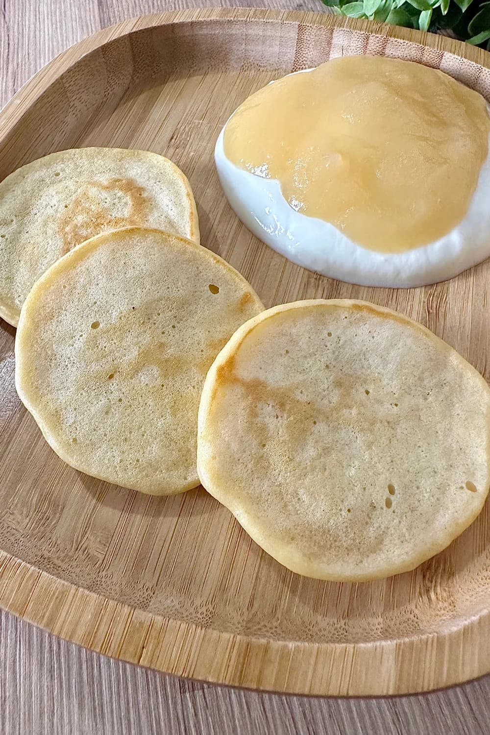 A stack of golden-brown applesauce pancakes topped with fresh apple slices and a drizzle of maple syrup. These soft and fluffy pancakes are naturally sweetened with applesauce, making them a healthy and tasty breakfast option.