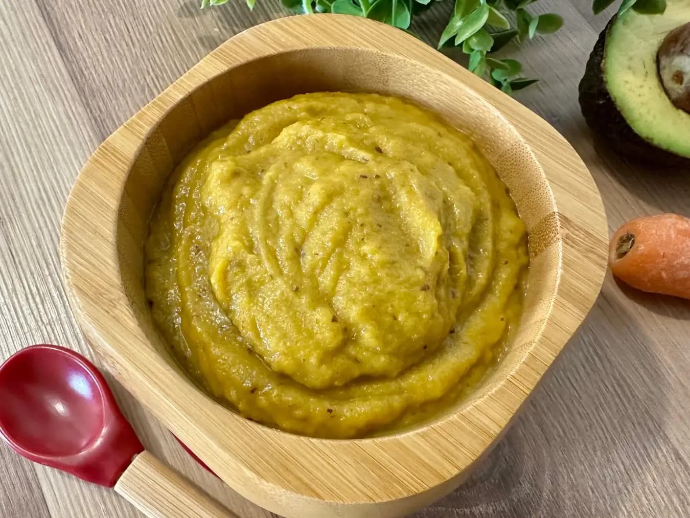 A smooth and creamy avocado, carrot, and prune puree served in a bowl, packed with essential nutrients for a healthy baby meal.