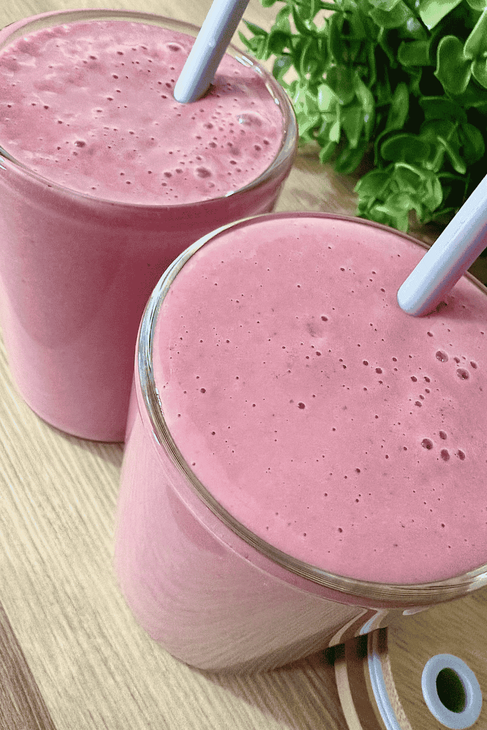 A vibrant pink beet strawberry banana smoothie served in a glass, garnished with fresh strawberry slices. This antioxidant-rich and naturally sweet smoothie is packed with beets, strawberries, and bananas, making it a healthy and delicious drink.