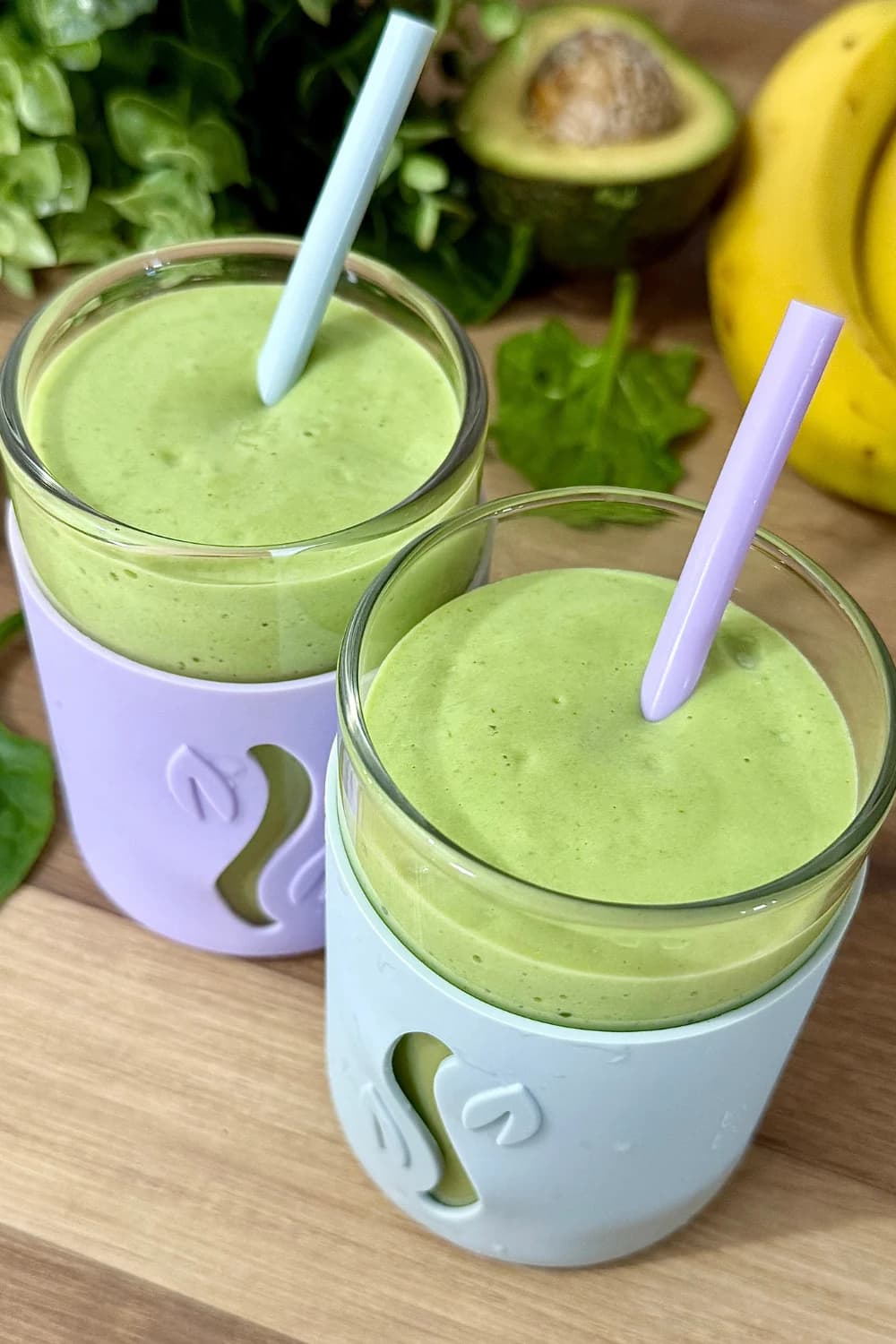 Creamy avocado banana spinach smoothie serve in a cup.
