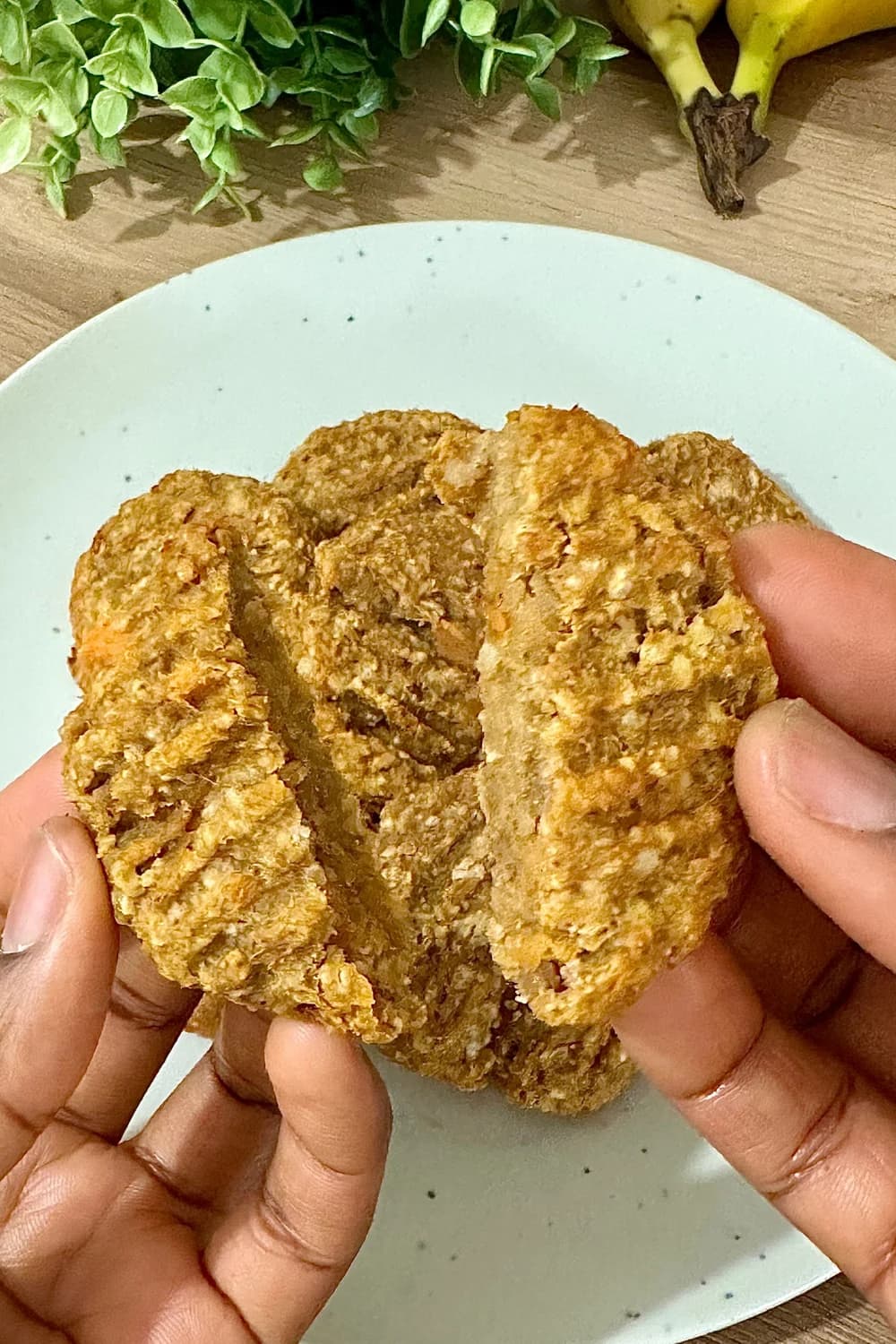 A plate of soft, golden-brown banana sweet potato cookies with a slightly textured surface, showcasing oats and a moist, chewy interior.