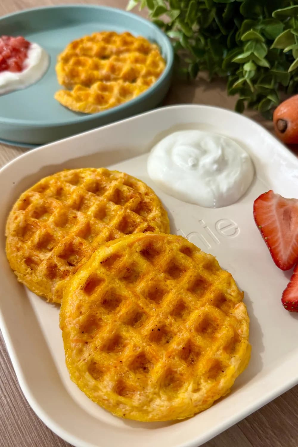 Golden brown cheesy carrot waffle stack on a plate.